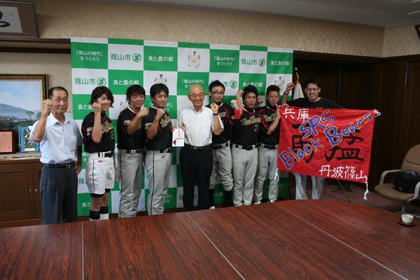 全国大会に初出場する「SRS ブラックビーンズ」のクラブチームの方々が市長を真ん中でガッツポーズをして笑顔で写っている写真